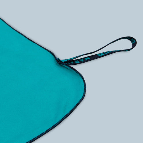 A photo of the Microfibre Towel Ultra Compact Double-Sided Size Xl 110 X 175 Cm - Blue Green in use