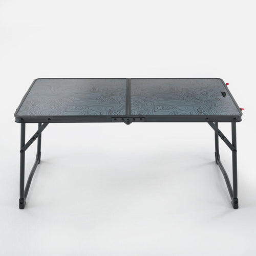 A photo of the Quechua MH100 Foldable Camping Coffee Table in use
