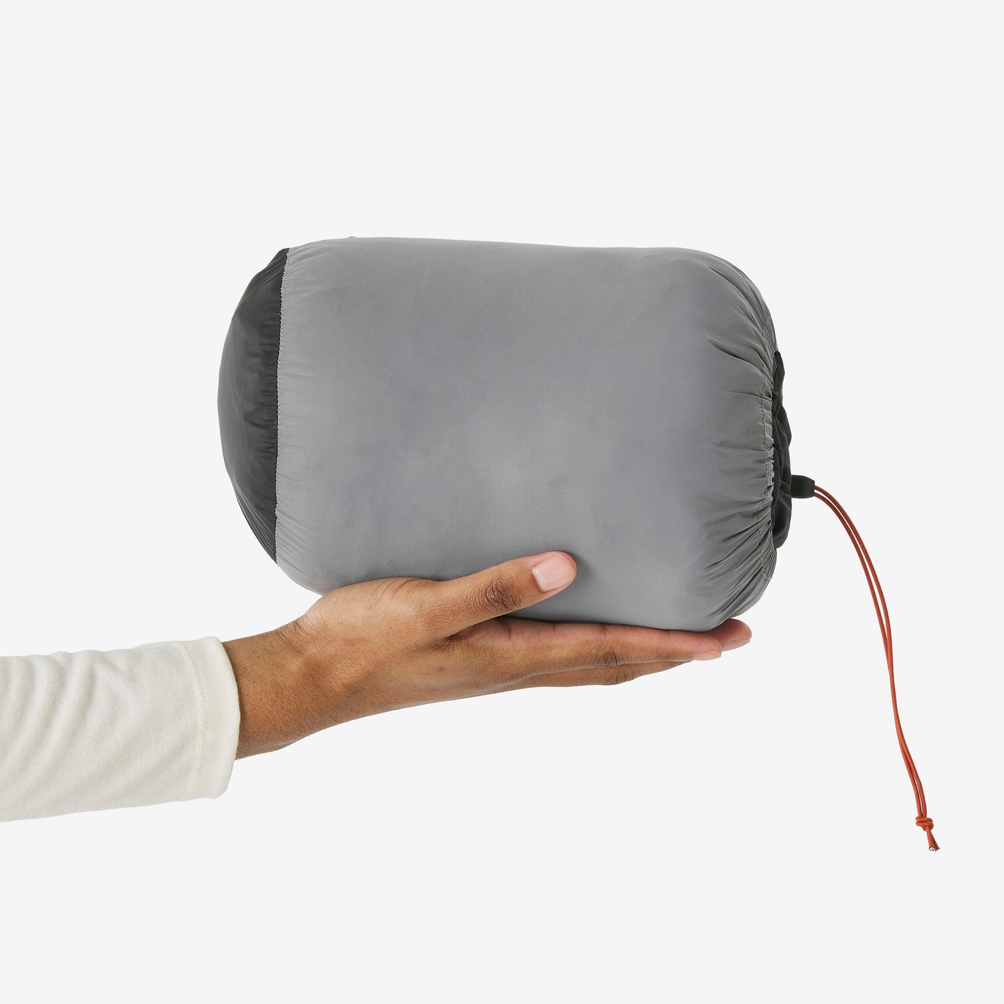 Hand holding a gray packed down jacket on a white background