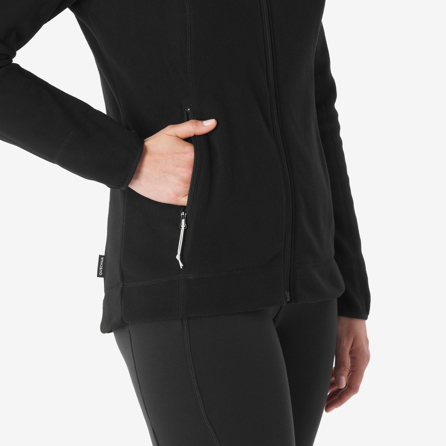 Person wearing a black jacket with a hand in the pocket on a white background