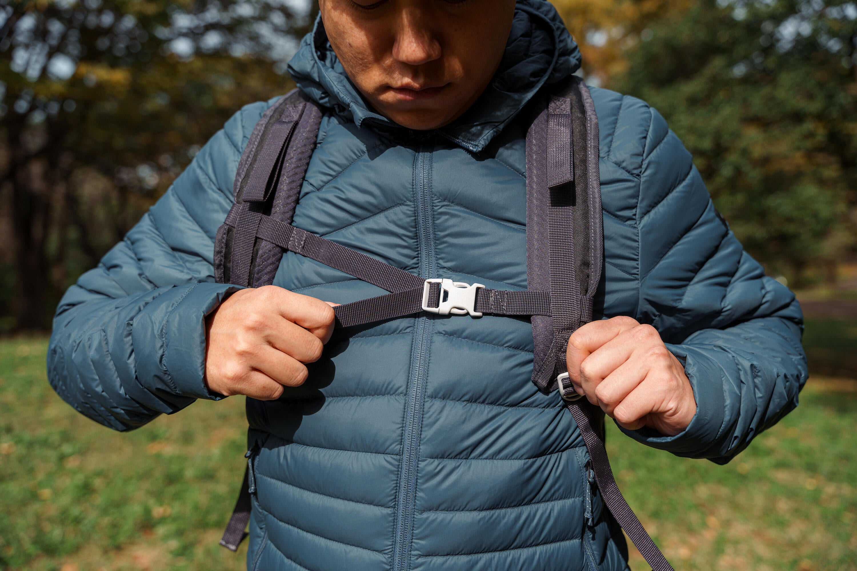 Person adjusting a backpack strap outdoors