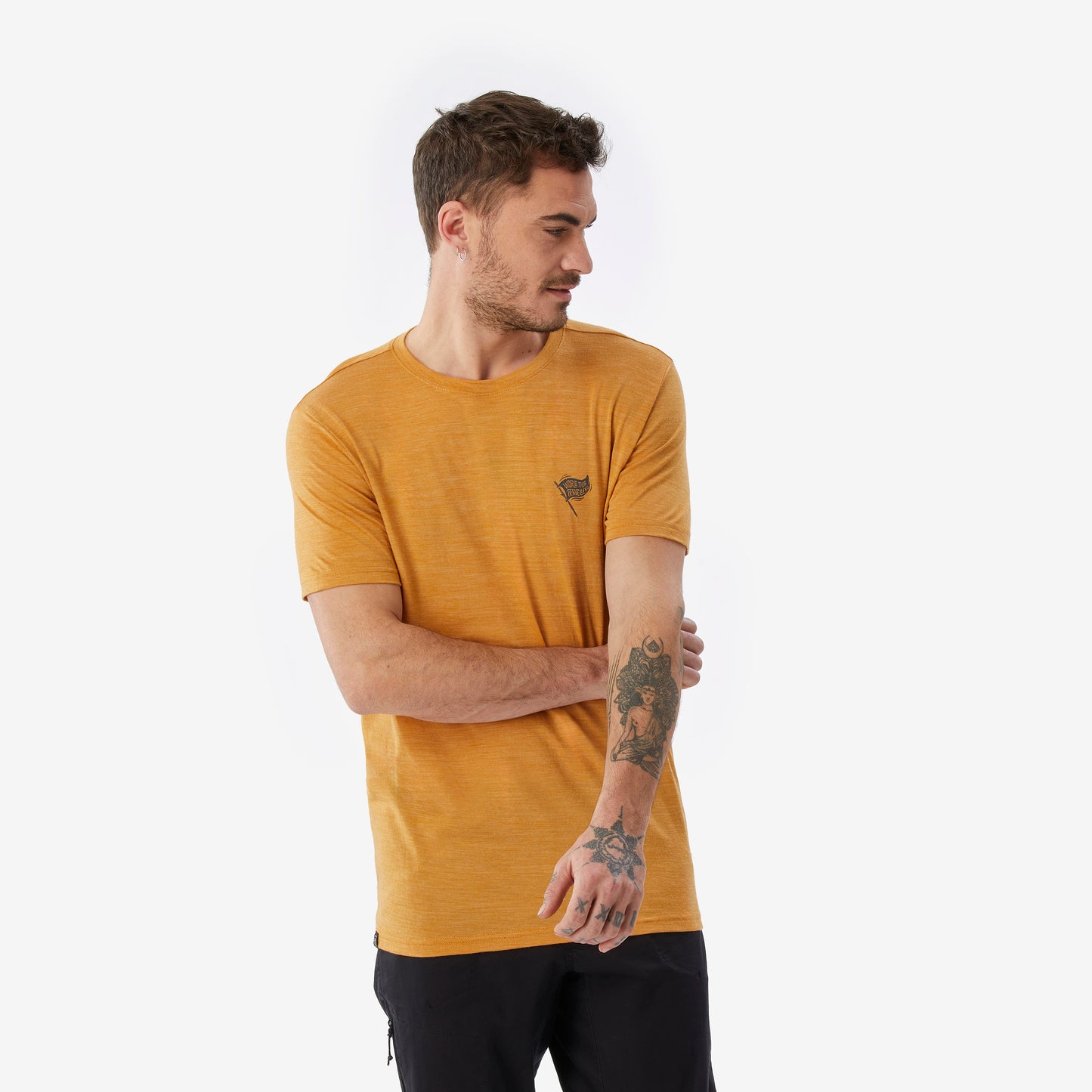 Man wearing a mustard yellow t-shirt with a small logo on a white background