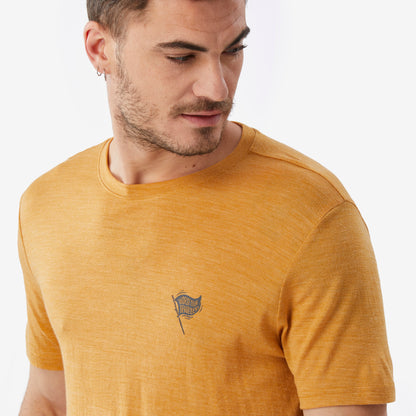 Man wearing a mustard yellow t-shirt with a small logo on a white background