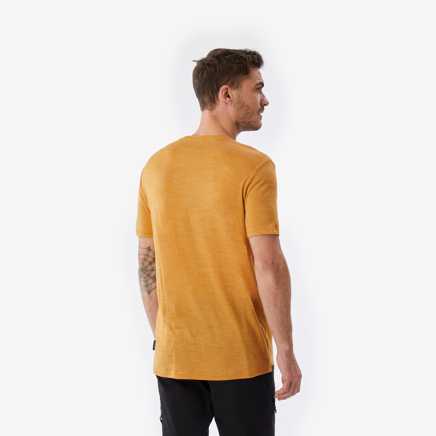 Man wearing a mustard yellow t-shirt on a white background