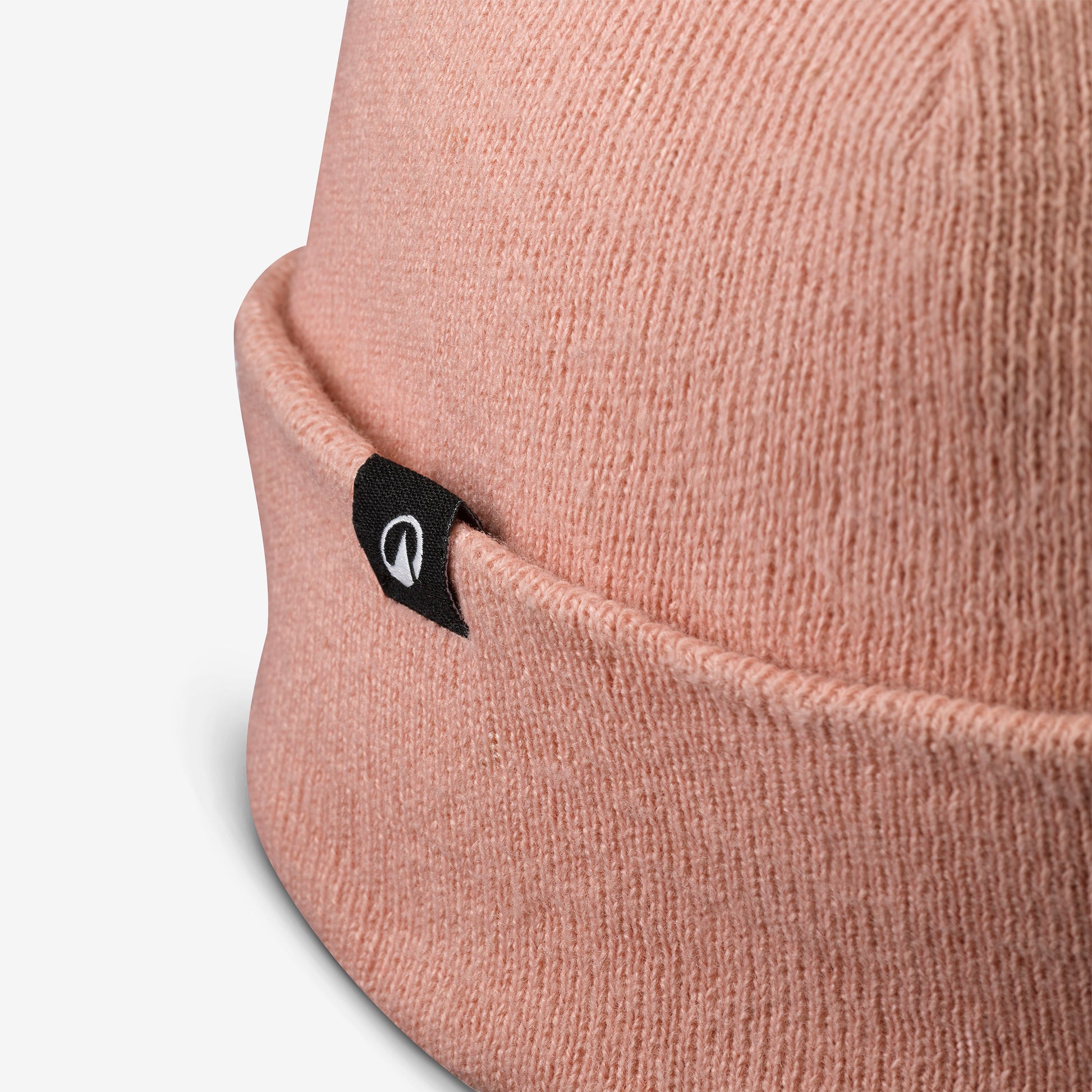 Close-up of a pink beanie with a brand logo on a white background