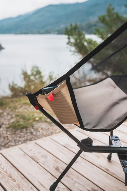 Chair on a wooden deck with a scenic view of a lake and mountains.