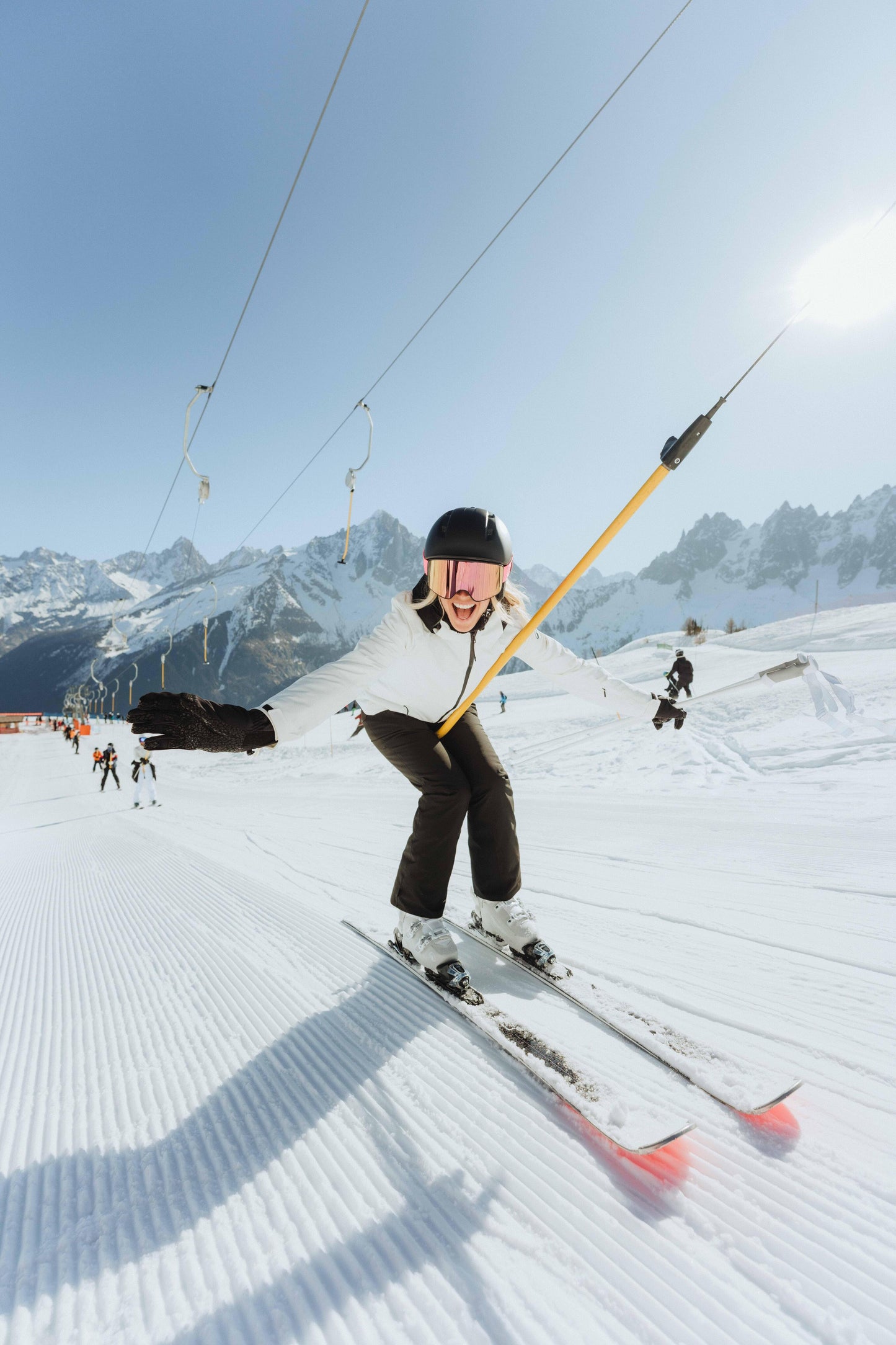 Person skiing on a snowy slope with mountains in the background