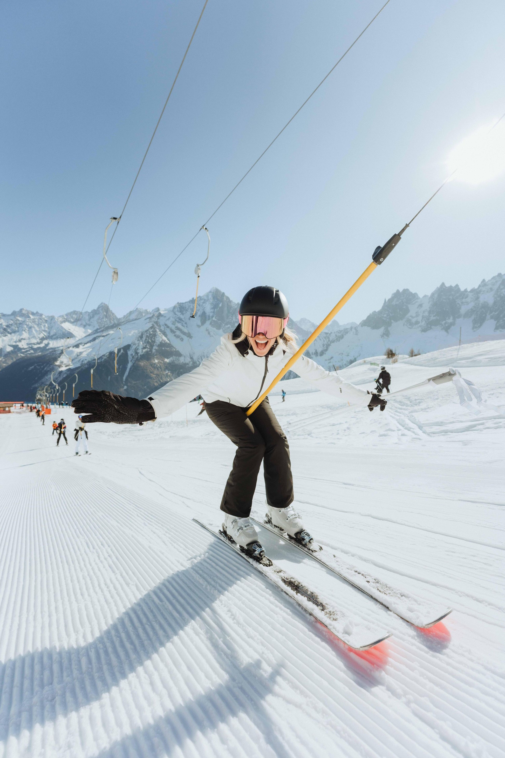 Person skiing on a snowy slope with mountains in the background