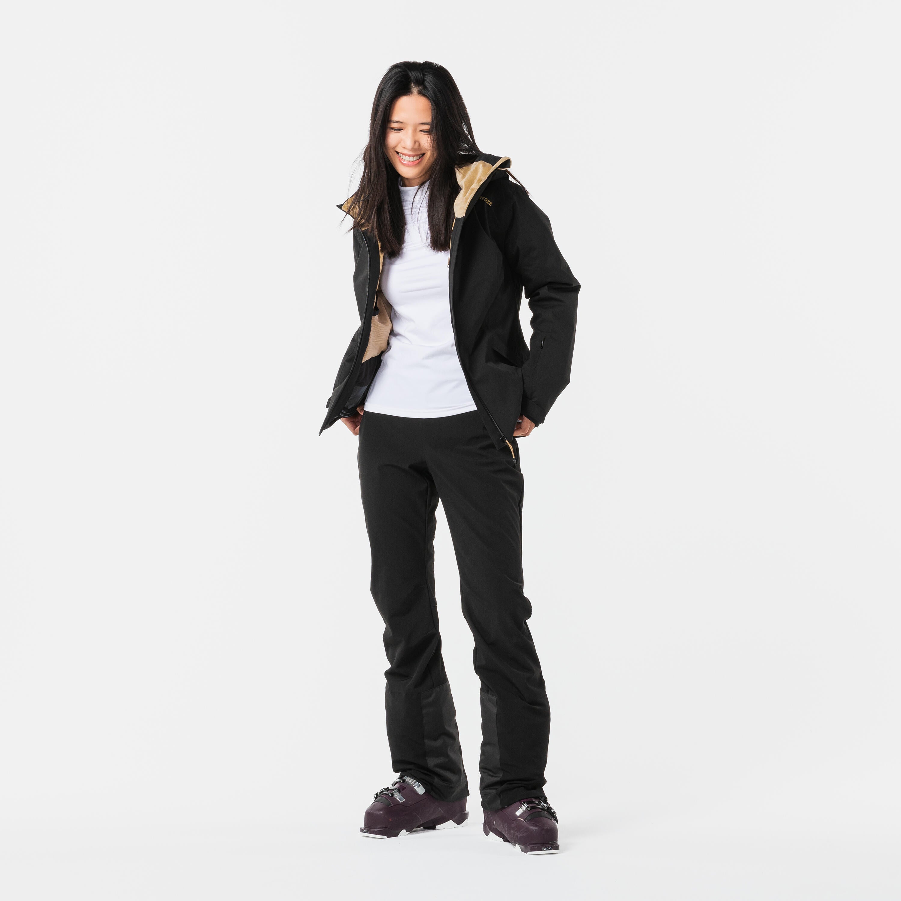 Person wearing a black coat with a hood and black pants on a white background